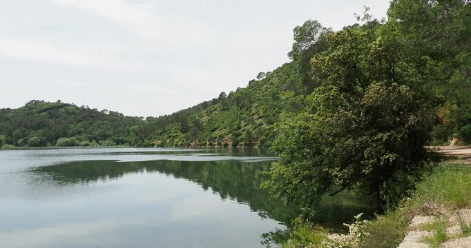 Paysage aquatique de Provence. Le lac Sainte Suzanne ou lac de Carc&egrave;s bord&eacute; de collines bois&eacute;es et d'un sentier de randonn&eacute;e paisible


