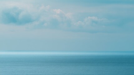 Obraz premium Tranquil ocean view showcases turquoise waters and soft sky with ethereal clouds