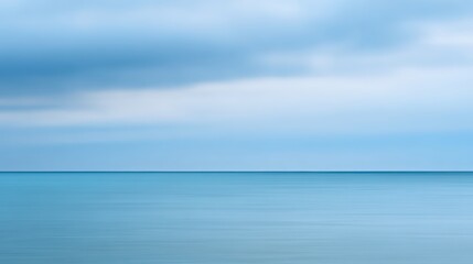 Obraz premium Serene seascape featuring a calm, turquoise sea meets a soft, cloudy sky for a peaceful feeling.