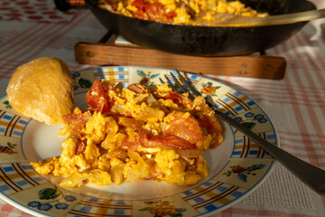 A serving of traditional Hungarian lecsó with scrambled eggs, featuring sautéed peppers, tomatoes, onions, and eggs on a colorful decorative plate. 