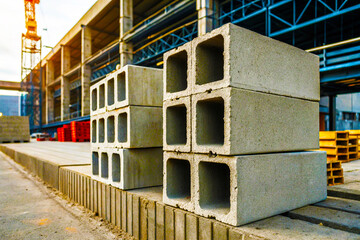 Stacked concrete blocks with square holes at a construction site during the daytime outdoors