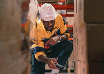 Warehouse manager, store inspector checking stock on storage shelf from inventory checklist. Two diverse ethnic people wear safety hard hat working together examining merchandise at distribution store