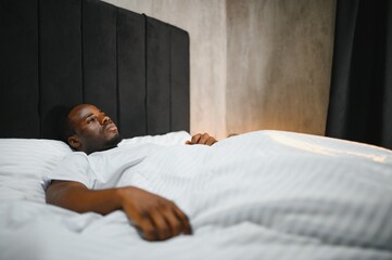 Young African Man Suffering From Fever Lying On Bed