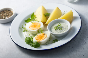 Hard boiled eggs with potato and green sauce