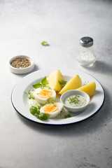 Hard boiled eggs with potato and green sauce