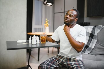 Sick African man with sore throat. Portrait of ill black man suffering from sore throat due to...