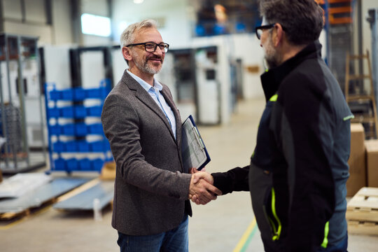 Professionals Shaking Hands in a Modern Industrial Facility Setting