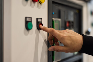 Close-Up of a Hand Pressing a Button on an Industrial Control Panel