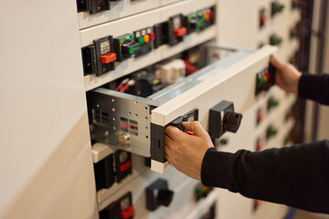Technician Adjusting Components in an Electrical Control Panel for Maintenance