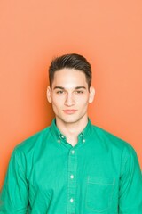 Obraz premium Professional young man portrait vivid green shirt bright orange background, confident business headshot perfect for corporate marketing, professional services and commercial advertising 