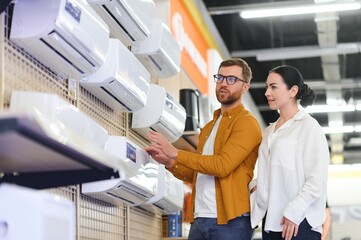 A beautiful couple chooses an air conditioner at home in an electronics store