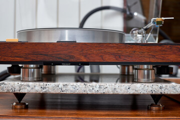 Obraz premium High-end audiophile turntable with wood plinth and acrylic dust cover on granite base.