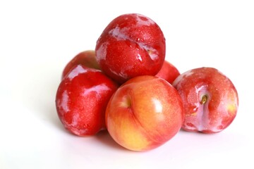 several red plums on a white background