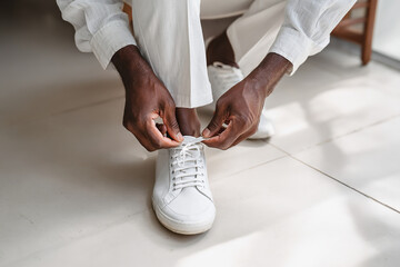 low angle crop of a man lace his shoes