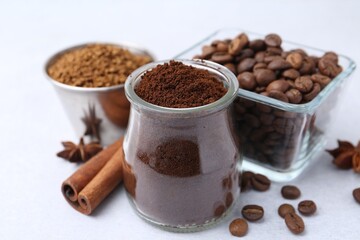 Different types of instant coffee, beans and spices on light table, closeup