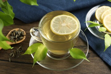 Refreshing green tea with lemon and leaves on wooden table, closeup