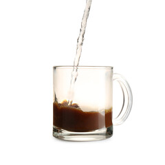 Pouring hot water into glass cup with instant coffee isolated on white, closeup