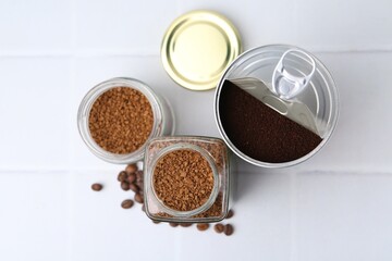 Instant coffee in jars and beans on white tiled table, flat lay