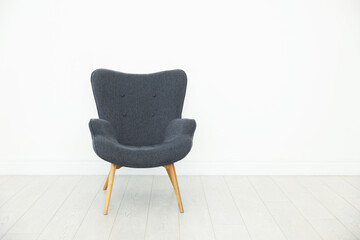 One comfortable armchair near white wall indoors, space for text