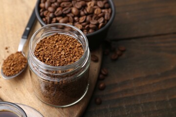 Instant coffee in glass jar and beans on wooden table, closeup. Space for text