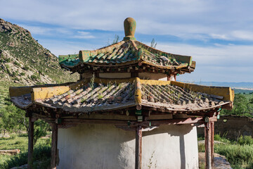 Ancient temple ruin with traditional roof in Mongolian steppe landscape