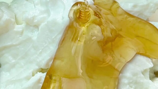 Close up pour  honey over Greek yogurt
