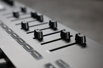 MIDI keyboard with faders on table, closeup