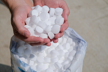 man hands holding salt for cleaning the pool