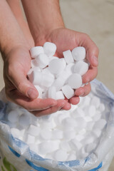 man hands holding salt for cleaning the pool