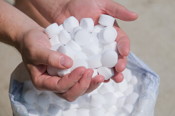 man hands holding salt for cleaning the pool
