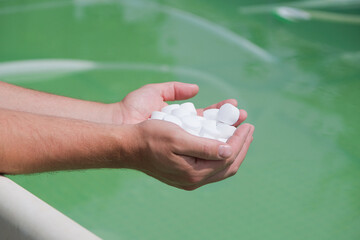 man hands holding salt for cleaning dirty pool