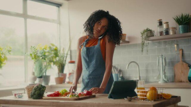 A woman with curly hair is preparing lunch while talking on the phone 