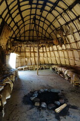 Vertical interior of a traditional Native American hut or tent with a woven reed ceiling and a...
