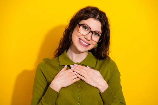Charming young woman in green attire on yellow background showcasing casual style and positive gestures