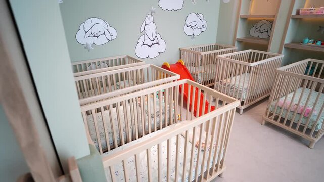 Daycare center in Karachi, Pakistan featuring wooden cribs, a slide, and pastel colored walls