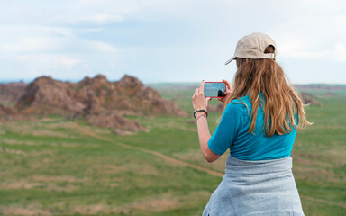 Young Woman Taking a Picture of Rocky Landscape with her Smartphone