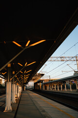 Vertical screen: modern architecture of empty train station platform with illuminated ceiling and...