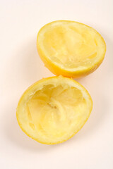 Two squeezed lemon halves on a white background