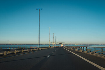 Driving on Oresund Bridge with clear blue sky and calm waters