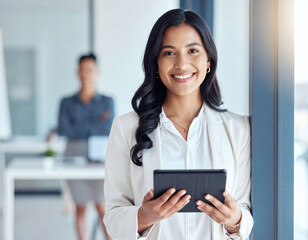 Portrait of young Hispanic professional business woman standing in office. Happy female company executive, smiling businesswoman entrepreneur corporate leader manager looking at camera using tablet.