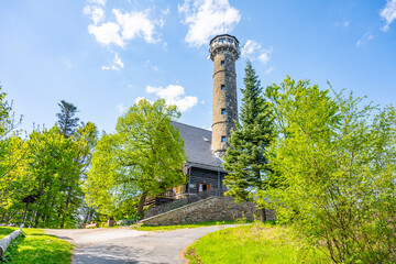 Svatobor lookout tower rises above the treetops, surrounded by vibrant greenery. Visitors can enjoy...