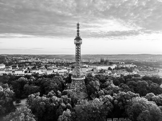 Early morning light casts a warm glow over Petrin Lookout Tower and the majestic Prague Castle,...