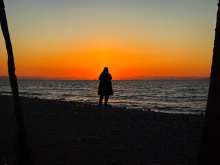 Fototapeta premium silhouette of a man walking on the beach
