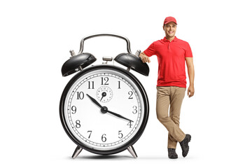 Full length portrait of a sales assistant leaning on a big alarm clock