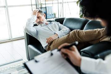Middle-aged man relaxing casually in therapy session at cozy office setting