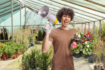 Male gardener holding flower pots and a megaphone