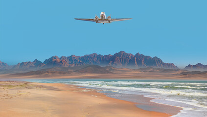 Old metallic propeller airplane in the sky, sunset clouds in the background - Namib desert with...