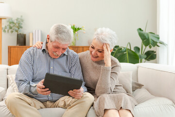 Senior old couple with tablet watching video online. Husband wife spending time together at home. Happy modern mature senior couple using tablet for family entertainment. Old people modern technology