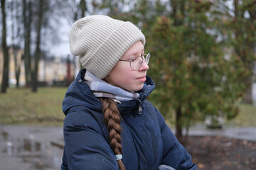 Teenager Girl Walking Alone on City Street with Smartphone. Portrait of 14 years old girl wearing...