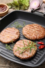 Delicious hamburger patties and spices on wooden table, closeup